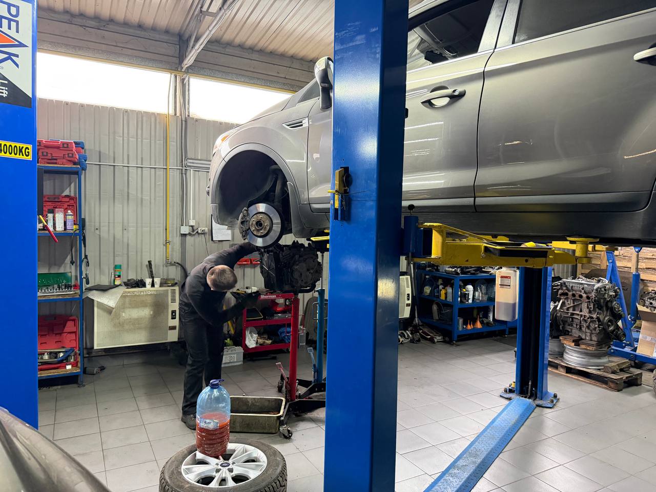 Мастер работает под автомобилем